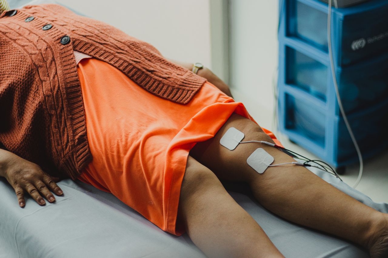 Services Close-up of a woman's legs during an electrical therapy session in a hospital setting.