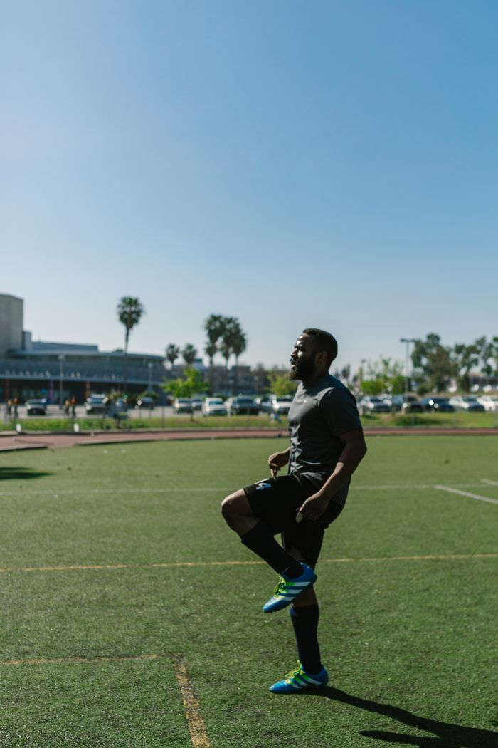 Services An athlete warms up on a sunlit soccer field, preparing for outdoor training.